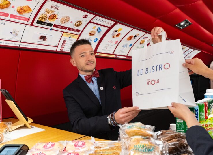 L'employé de la SNCF vend de aliments dans le wagon-bistro